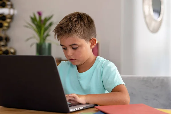 家に座っている間 テーブルの上でノートパソコンの上で宿題をするかわいい白人の焦点を当てた少年 コピースペース 変更されていない 子供時代 無線技術 オンライン Eラーニングの概念 — ストック写真