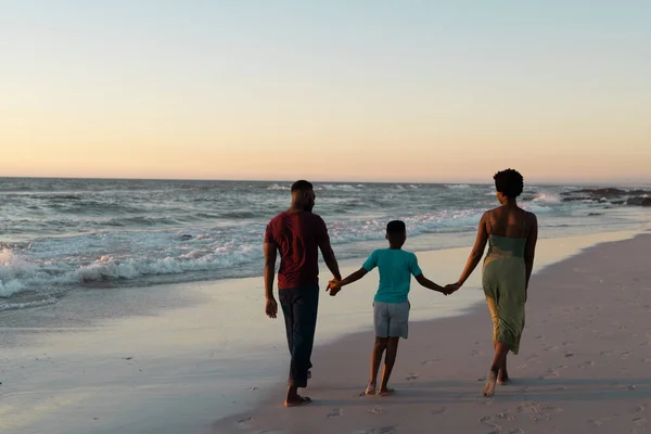 Tylny Widok Afrykańskiego Amerykańskiego Chłopca Trzymającego Rodziców Ręce Spacerującego Plaży — Zdjęcie stockowe