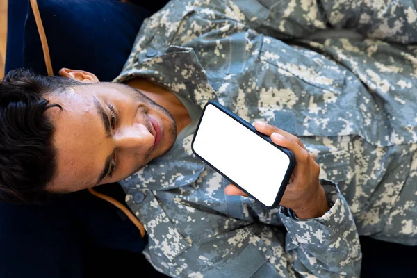 Soldado Masculino Birracial Feliz Vestindo Uniforme Deitado Sofá Usando Smartphone — Fotografia de Stock