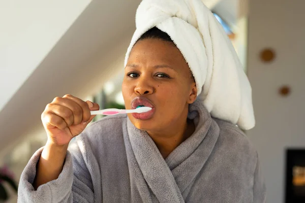快乐又大的非洲女人穿着长袍 在浴室刷牙 自我照顾 健康和美 身体包容和生活方式 — 图库照片
