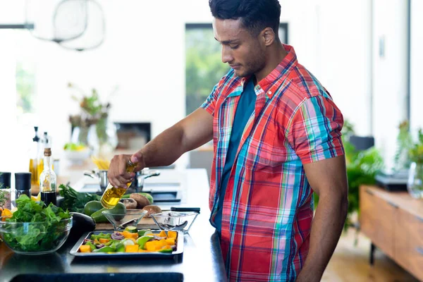 Happy Biracial Man Preparing Dinner Pouring Oil Vegetables Kitchen Lifestyle — Stock Photo, Image