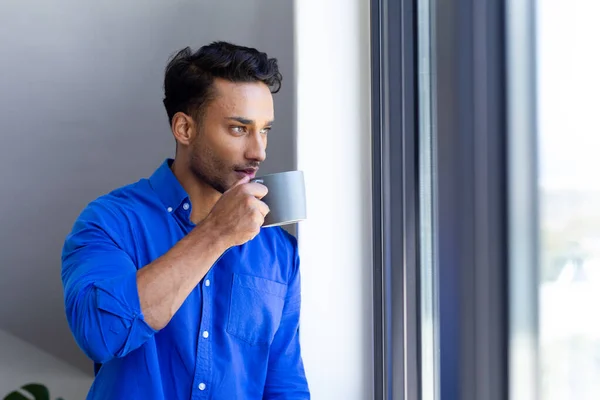 Glad Biracial Man Dricker Kaffe Och Tittar Genom Fönstret Avkoppling — Stockfoto
