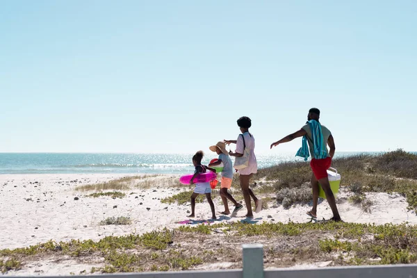 アフリカ系アメリカ人の両親と子供たちは 涼しい 水泳のフロート 空の下でビーチでボールウォーキング コピースペース 変更されていない 一緒に 子供時代 ピクニック 楽しみと夏 — ストック写真