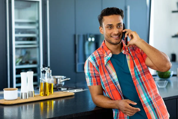 Happy Biracial Man Leaning Counter Talking Smartphone Kitchen Lifestyle Technology — Stock Photo, Image