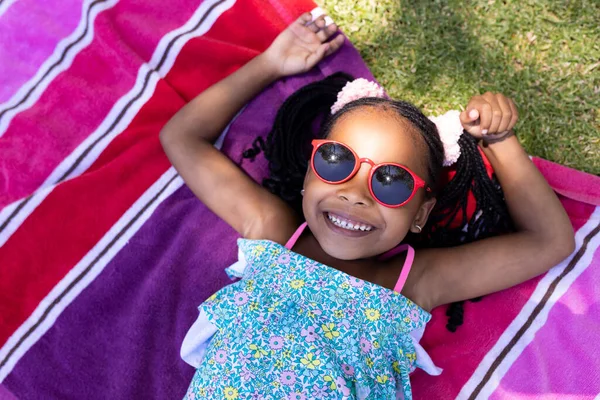 Havluya Uzanmış Güneş Gözlüğü Takan Sevimli Afro Amerikan Kız Manzarası — Stok fotoğraf