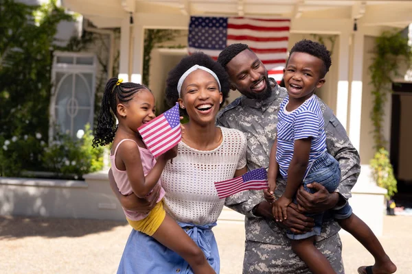 非裔美国军人的丈夫和母亲背着美国国旗的孩子走出家门 不变的家庭 爱国主义和归国观念 — 图库照片