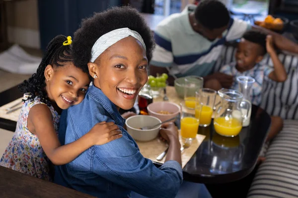 明るいアフリカ系アメリカ人の母親と娘が自宅のダイニングテーブルに座っている高角度の肖像画 変更されていない 一緒に 子供時代 食べ物 新鮮で幸せとライフスタイルの概念 — ストック写真