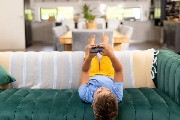 Biały Chłopiec Korzystający Telefonu Komórkowego Leżącego Kanapie Salonie Kopiujący Przestrzeń — Zdjęcie stockowe