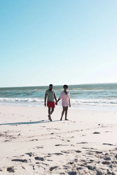 アフリカ系アメリカ人の大人のカップルが手を取り合い 美しい海と空に向かってビーチを歩く コピースペース 変更されていない 楽しさと夏のコンセプト — ストック写真