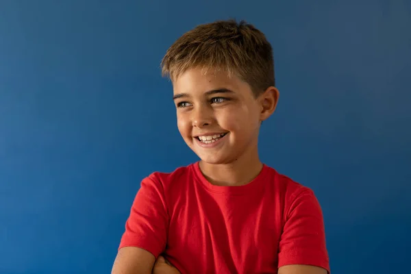 Portret Białego Uśmiechniętego Chłopca Odwracającego Wzrok Stojącego Niebieskim Tle Kopiuj — Zdjęcie stockowe