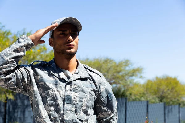 Biracial Mannlig Soldat Iført Militær Uniform Hilser Utendørs Med Kopiplass – stockfoto