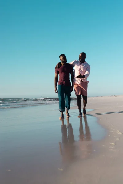 アフリカ系アメリカ人の半ば大人の息子高齢者の父親と話をし 澄んだ空に対して海岸を歩く コピースペース 変更されていない 一緒に 楽しさと夏 — ストック写真
