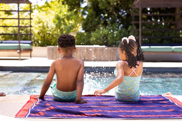 Rear View African American Siblings Splashing Water Pool While Sitting — Stock Photo, Image