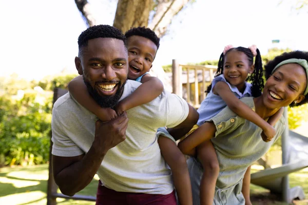 Afro Americanos Sonriendo Padres Cuestas Hijo Hija Mientras Están Pie —  Fotos de Stock