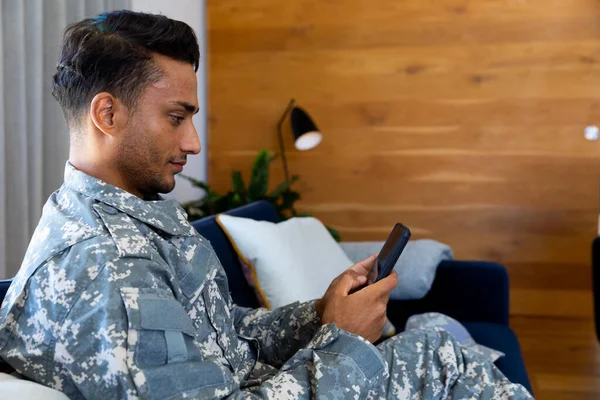 Feliz Soldado Birracial Con Uniforme Militar Sentado Sofá Usando Teléfono — Foto de Stock