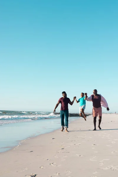 陽気なアフリカ系アメリカ人の父親と祖父は少年の手を握ってビーチで彼を拾う コピースペース 変更されていない 多世代の家族 一緒に 楽しむ — ストック写真