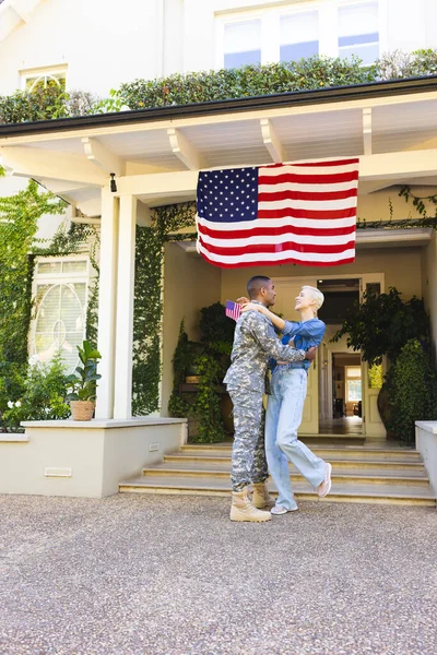 Lykkelig Hvit Kvinne Etnisk Amerikansk Soldat Som Omfavner Utenfor Huset – stockfoto