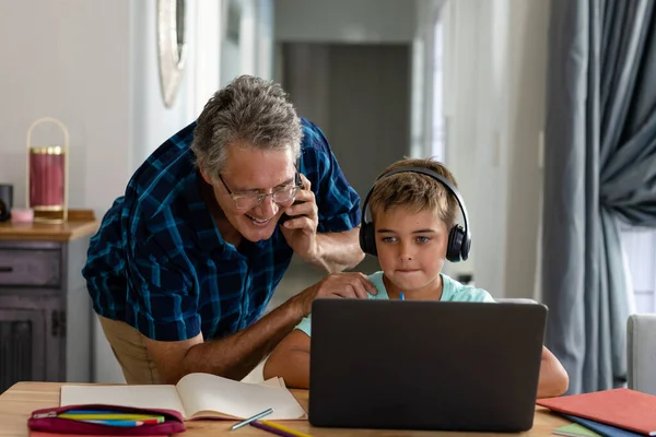 Vit Farfar Pratar Över Telefon Och Tittar Laptop Som Används — Stockfoto