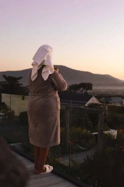加尺寸的非洲裔美国女人头戴长袍和毛巾 在阳台上喝茶 身体包容 生活方式和自我照顾 — 图库照片