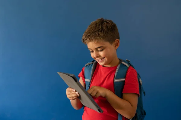 Sonriente Chico Caucásico Con Bolsa Escuela Usando Tableta Digital Mientras —  Fotos de Stock