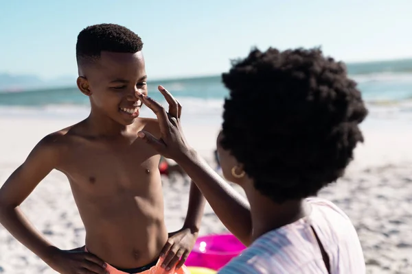 Afrikansk Amerikansk Mor Applicerar Solkräm Sonens Näsa Stranden Mot Klar — Stockfoto