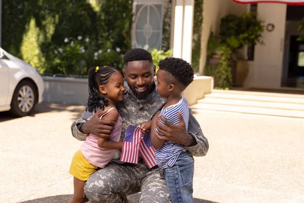 非裔美国军人的父亲在外面拥抱可爱的孩子 不变的家庭 美国国旗 爱国主义和归国观念 — 图库照片