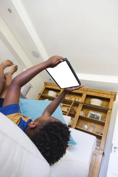 Afrikanischer Junge Sitzt Auf Sofa Und Benutzt Tablet Mit Kopierplatz — Stockfoto
