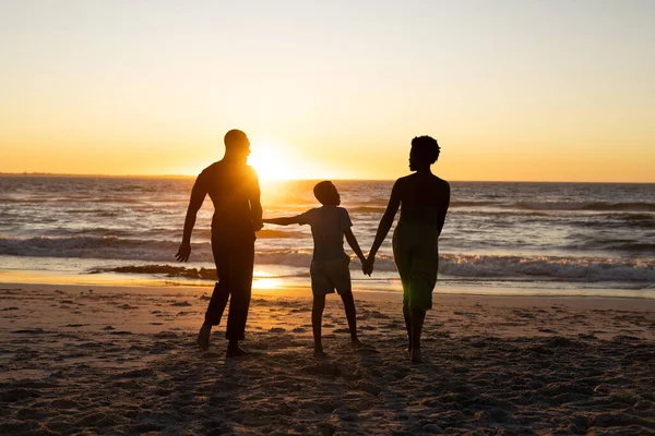 Sylwetka Afrykańskiego Chłopca Trzymającego Rodziców Ręce Stojącego Plaży Zachodzie Słońca — Zdjęcie stockowe