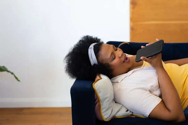Mutlu Afro Amerikan Kadın Kanepeye Uzanıp Akıllı Telefondan Konuşuyor Rahatlama — Stok fotoğraf