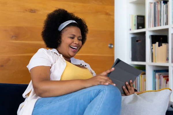 快乐加尺寸的非洲裔美国女人坐在沙发上 用平板电脑 家庭生活 身体包容和生活方式 — 图库照片