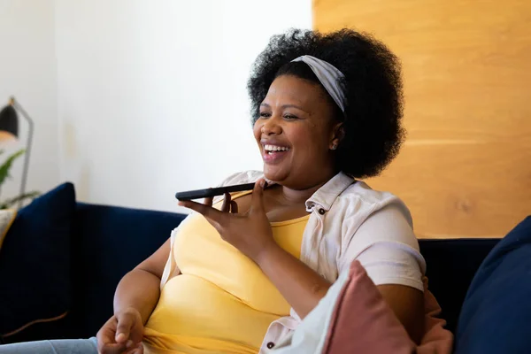 Щаслива Велика Афро Американська Жінка Яка Сидить Дивані Розмовляючи Смартфоні — стокове фото