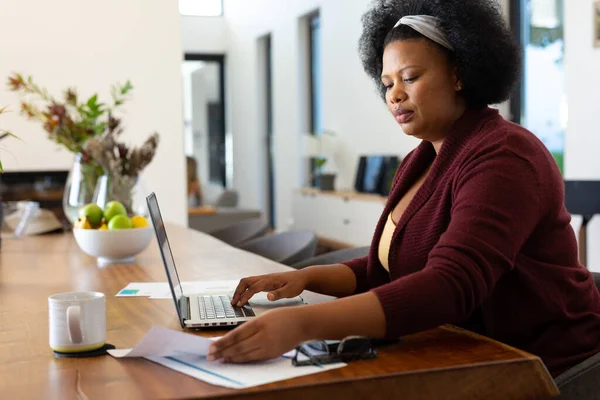 Amerykańska Kobieta Afryki Siedząca Przy Stole Używająca Laptopa Przeglądająca Dokumenty — Zdjęcie stockowe
