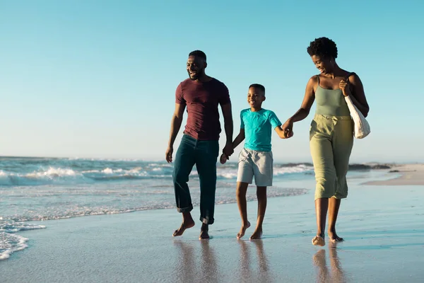 父親と母親の手を取り 空に向かって海岸を歩く陽気なアフリカ系アメリカ人の少年 コピースペース 変更されていない 一緒に 子供時代 楽しみと夏 — ストック写真