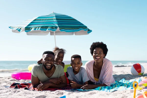 Uśmiechnięci Afrykańscy Rodzice Dzieci Leżące Ręcznikach Piaszczystej Plaży Pod Czystym — Zdjęcie stockowe