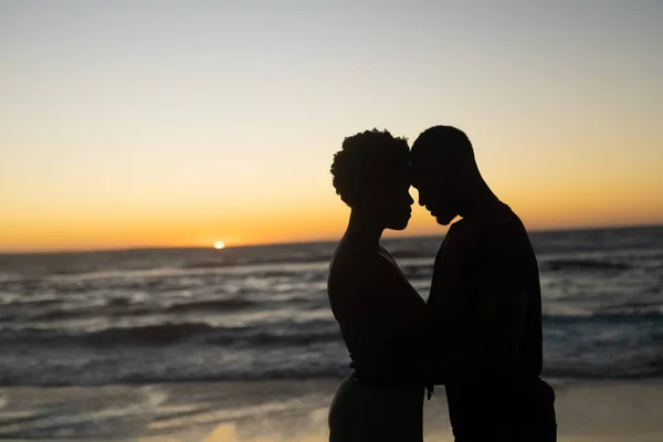 シルエットアフリカ系アメリカ人のロマンチックなカップルは 日没時にビーチに立って頭に コピースペース 変更されていない 一緒に 風景と親密概念 — ストック写真