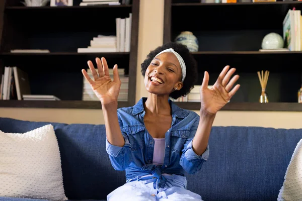 Счастливая Африканская Американка Короткими Афро Волосами Жестикулирующая Сидя Диване Гостиной — стоковое фото