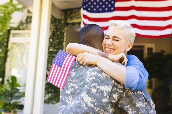 Feliz Mujer Caucásica Soldado Birracial Americano Abrazándose Fuera Casa Bandera — Foto de Stock