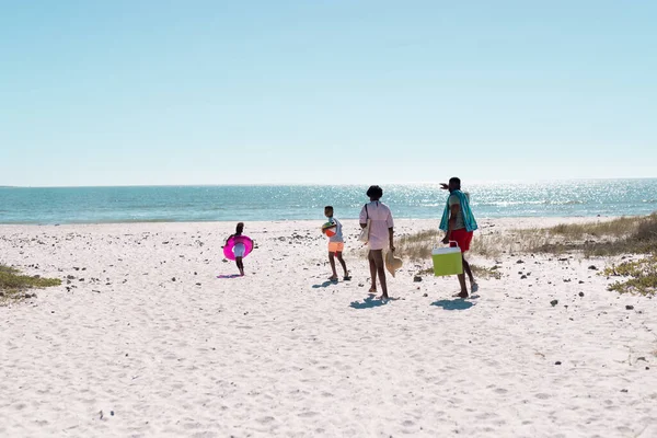アフリカ系アメリカ人の両親は夏に澄んだ空を背景にビーチを走る遊び心のある子供たち コピースペース 変更されていない 一緒に 子供時代 ピクニック 楽しみ — ストック写真