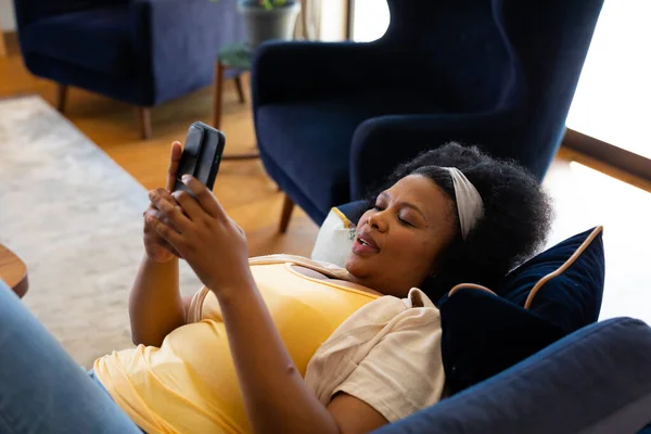 Boldog Plusz Méretű Afro Amerikai Fekszik Kanapén Okostelefont Használ Pihenés — Stock Fotó