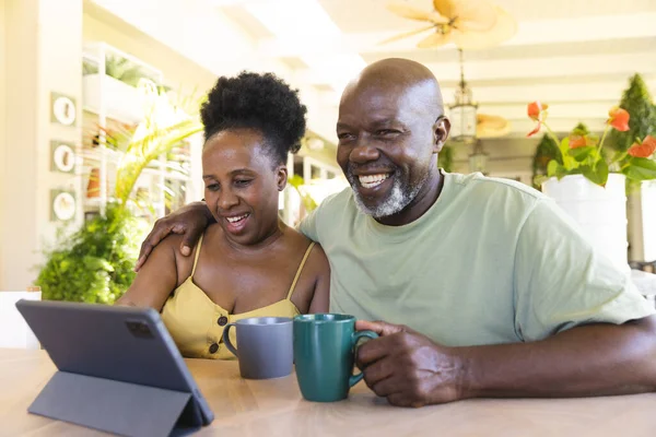 Feliz Casal Afroamericano Sênior Usando Tablet Com Xícaras Café Estilo — Fotografia de Stock