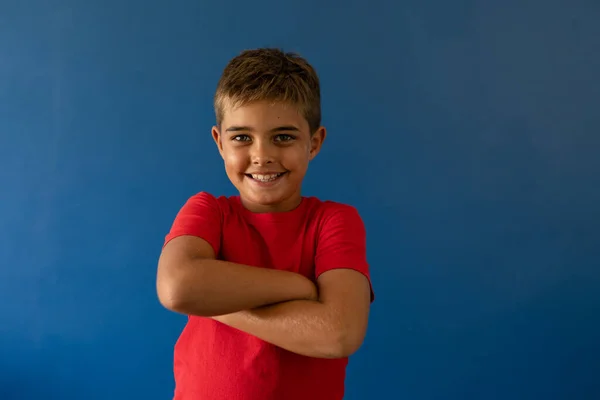 Kolları Mavi Arka Planda Çapraz Duran Gülümseyen Beyaz Bir Çocuğun — Stok fotoğraf