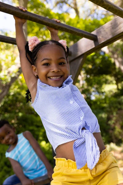 遊び場でサルバーにかかってアフリカ系アメリカ人のかわいい笑顔の女の子の低角度ビュー 変更されず 子供時代 楽しみ 週末のコンセプト — ストック写真