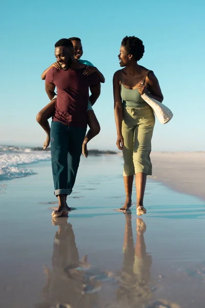Alegre Hombre Afroamericano Cuestas Hijo Mientras Camina Con Esposa Orilla —  Fotos de Stock