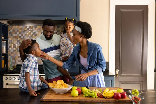 Αφροαμερικανή Μητέρα Που Ταΐζει Φρέσκα Φρούτα Παιδιά Και Συζύγους Ενώ — Φωτογραφία Αρχείου