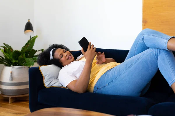 Happy Size Mulher Americana Africana Deitada Sofá Usando Smartphone Relaxamento — Fotografia de Stock