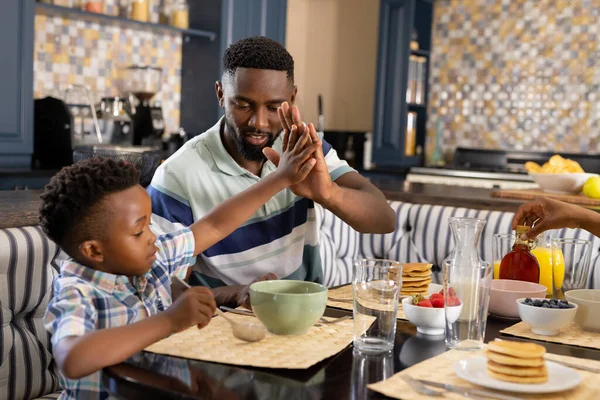 非洲裔美国人的父亲和儿子在家里吃早餐的时候互赠五块钱 采购产品不变的 餐桌和快乐的概念 — 图库照片