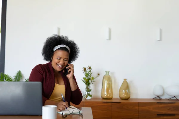 Masada Dizüstü Bilgisayarlı Akıllı Telefondan Konuşan Afro Amerikan Kadın Var — Stok fotoğraf
