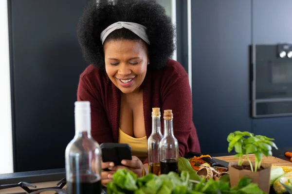 Щаслива Велика Афро Американська Жінка Користуючись Смартфоном Готує Їжу Кухні — стокове фото