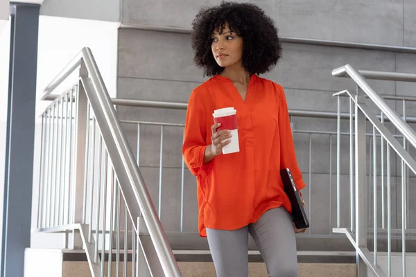 快乐的非洲裔美国女商人带着外卖咖啡走在楼梯上 通勤和办公室概念 — 图库照片