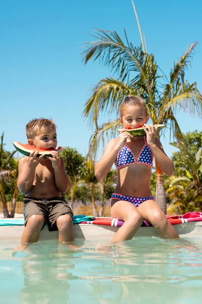 快乐的哥哥和姐姐在游泳池边吃西瓜 花费高质量的时间 生活方式 夏季和假期概念 — 图库照片
